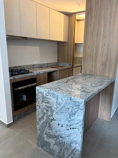 Ilha de cozinha em granito cinza com cooktop embutido
